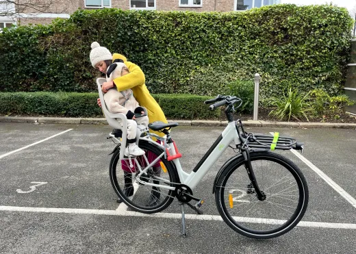 Mum lifting her toddler into the child seat at handover