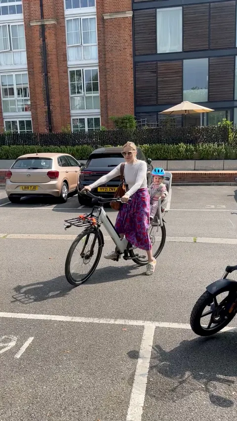 Mum riding an electric bike with her toddler in the child seat